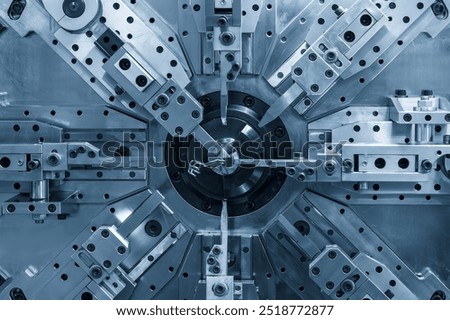 Close up the coil spring making machine in light blue scene. The mechanical parts manufacturing concept.
