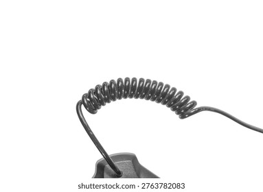 Close up of coiled black plastic cable showing spring structure. Telecommunication equipment connection wire. Flexible curly cord used for electronic devices and phones.