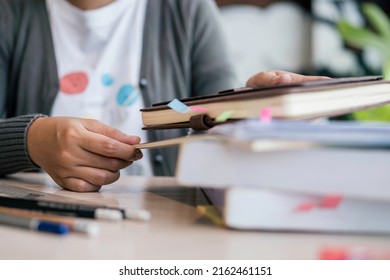 Close Up Of College Student Hands Finding Paper Information Sheets To Prepare For Exam