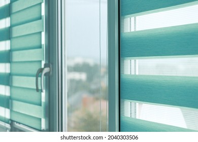 Close up of colored fabric roller blinds on window. Roll curtains.