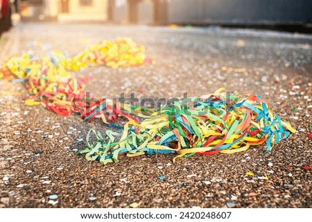 Close up colorful confetti and streamers at the street after Carnival parade