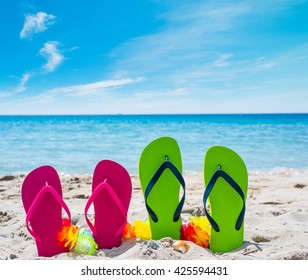 Close Up Of Colorful Flip Flops On The Sand