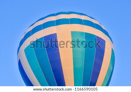 Close up of a colorful hot air balloon in blue sky. Bottom view.