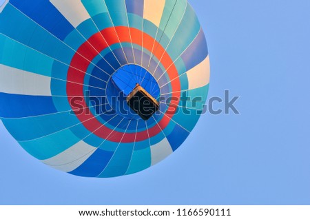 Close up of a colorful hot air balloon in blue sky. Bottom view.