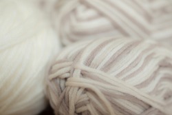 Close Up Colorful Yarn Texture Background, Pale Brown And Pastel Creamy Beige Strains, Coiled In Ball Skein. Knitting And Crochet, Home Craft Work. Hazy Blurred Mild Defocus. Winter Color Combination.