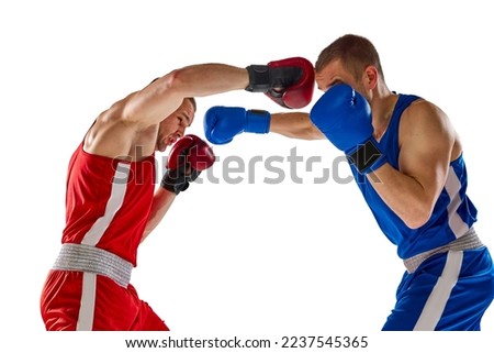 Close combat. Two twins brothers, professional boxers in blue and red sportswear boxing isolated on white background. Concept of sport, competition, training, energy. Closeup