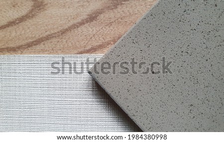 close up combination of interior material including grey grained artificial stone or quartz ,grey textile linen fabric wallpaper ,oak wooden vinyl floor tile samples. interior mood tone board.