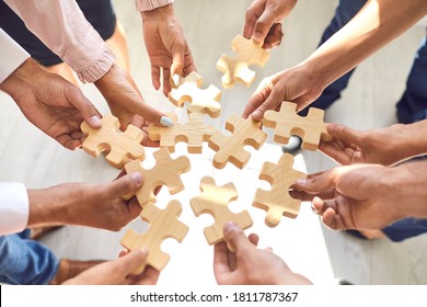 Close Up Of Company Workers Finding Solution In Corporate Work Meeting. Cropped Office Employees Learning To Collaborate And Playing With Pieces Of Jigsaw Puzzle During Team Building Activity