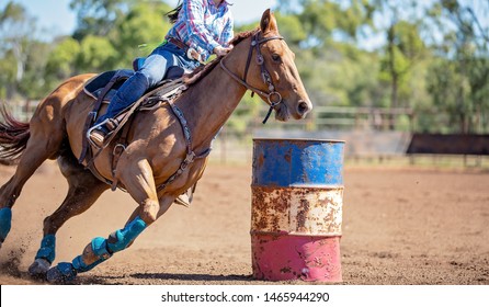 Close up of competitor on horseback making a figure eight turn in a barrel race at outback country rodeo