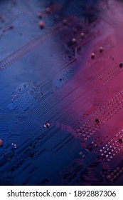 Close up of computer circuit board in blue and red lihgts.