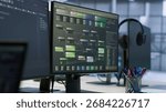 Close up of computer displays in empty data center establishment monitoring hardware energy consumption. PC screens on server hub office desk showing programming software, handheld camera shot