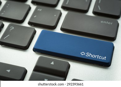 Close Up Computer Keyboard Focus On A Blue Button With Typographic Word Shortcut And Arrow Sign.