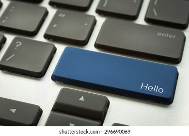 Close up computer keyboard focus on a blue button with typographic word HELLO search engine optimization and computer sign. Language and social media concepts.