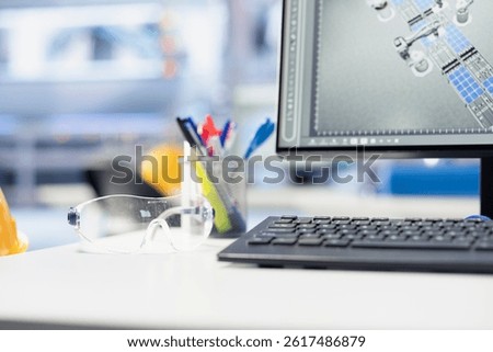 Close up of computer on desk displaying live metrics in renewable energy facility, tracking solar panel assembly progress. Stationary items on photovoltaics factory engineering workspace desk