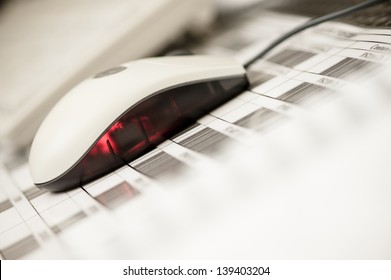 Close of a computermouse lying on a paper with barcodes