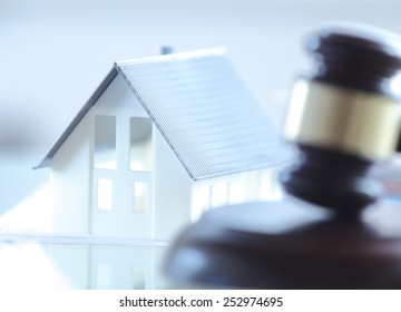 Close up Conceptual White Miniature House on Top of the Table Beside Court Gavel.
