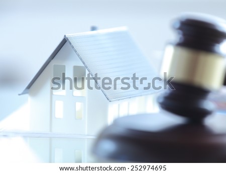 Close up Conceptual White Miniature House on Top of the Table Beside Court Gavel.