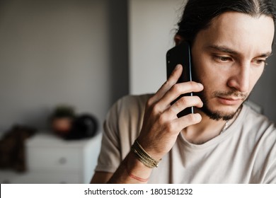 Close Up Of A Concerned Mman Talking On Mobile Phone Indoors