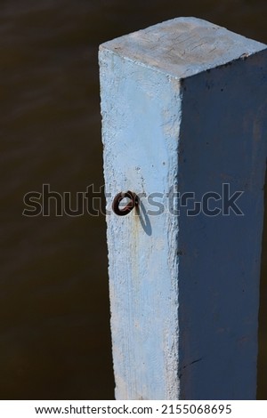 Close up Concrete pole with chains hooks on jetty, Blue Jetty pole,  Blue concrete pier pillars  with sunlight.
