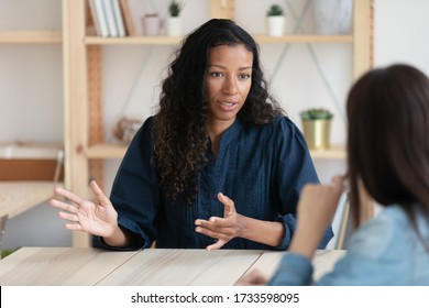 Close up confident african american businesswoman explaining new responsibilities to female applicant. Attractive young diverse woman hr manager talking and introduction company to job seeker. - Shutterstock ID 1733598095