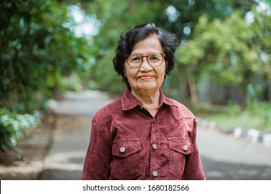 Close Up Confident Asian Grandma Wearing Eyes Glasses Stand In The Park