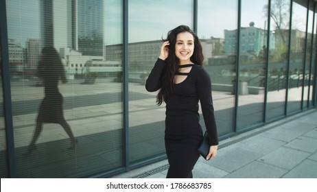 Close Up Confident Business Woman Smiling At Street. Modern Woman Entrepreneur Walking In Black Dress Outside. Successful Woman Touching Hair In Luxury Dress At Street.