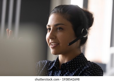 Close Up Of Confident Indian Female Call Center Agent In Headset Consult Client Online. Young Ethnic Woman In Headphones Speak Talk On Video Conversation, Have Webcam Virtual Conference.