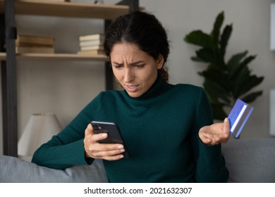 Close up confused woman having problem with credit card, using phone, dissatisfied young female using internet banking service, checking balance, loss money, internet fraud and scam concept