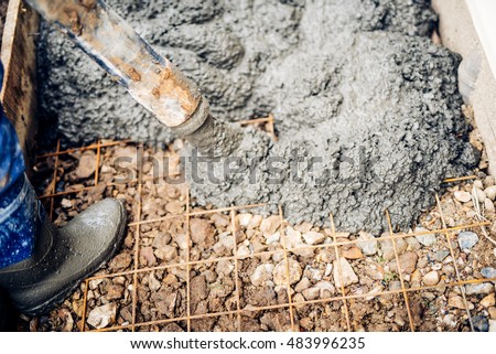 close up of construction workers using cement pump tube 