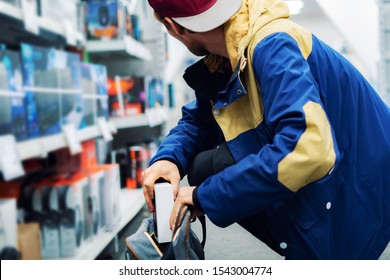 close up consumer  thief’s hands putting the new gadget in the pocket in the store 