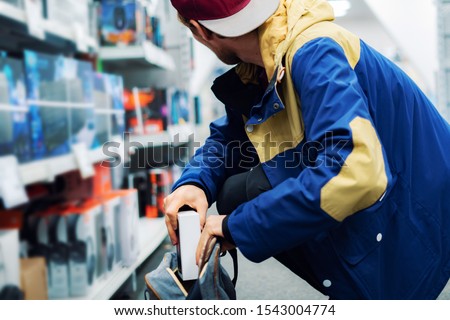 close up consumer  thief’s hands putting the new gadget in the pocket in the store 