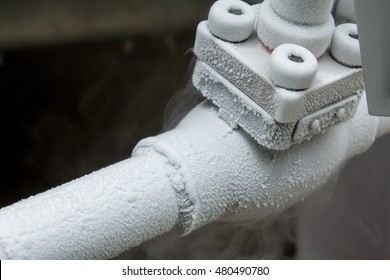 Close up of container with liquid nitrogen,Cold metal pipe smoking from transferring liquid nitrogen - Powered by Shutterstock