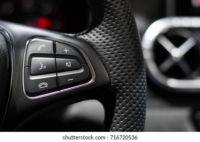 Close up of control buttons on a steering wheel switch in a car.