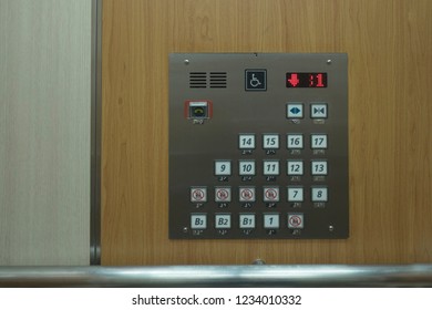 Close up of control elevator buttons for disabled human on wooden wallpaper.