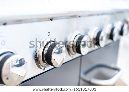 Close up of control knobs on an outdoor gas grill.