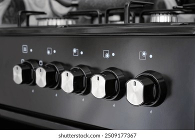 Close up of control panel with knobs for gas stove in home kitchen. Selective focus.