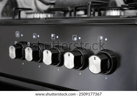 Close up of control panel with knobs for gas stove in home kitchen. Selective focus.