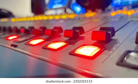Close up of a control panel of a sound recording studio with red light.