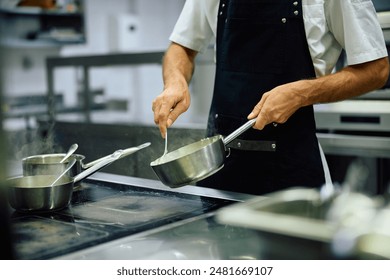 Close up of cook preparing meal while working in restaurant. 