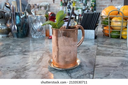 Close up of copper mug with Kentucky Mule or Moscow Mule on marble bartop.