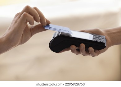 Close up with copy space unknown customer hold credit or debit card make easy payment on card reader machine with wireless NFC technology, client pay for order on terminal contactless, cashless method