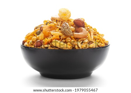 Close up of corn flex mixture Indian namkeen (snacks) on a ceramic black bowl. 