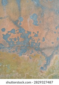 Close up of a corroded metallic surface with dynamic orange and blue pattern