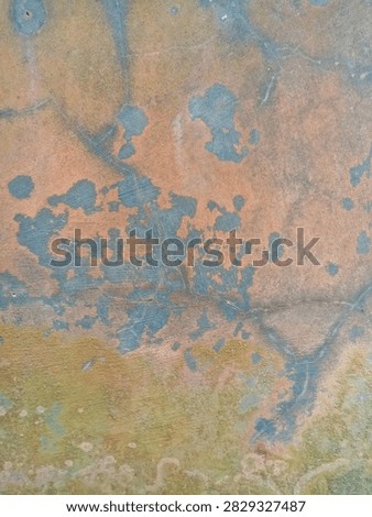 Close up of a corroded metallic surface with dynamic orange and blue pattern