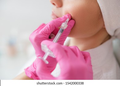 Close Up Of Cosmetologist In Sterile Gloves Making Injection In Lady Cheek Stock Photo