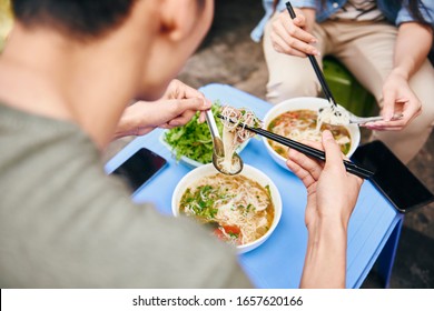 Close Up Of Couple Eating Pho Soup In The City 