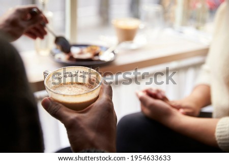 Close up of couple enjoying coffee and cake in cafe