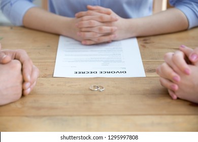 Close Up Of Couple Getting Divorced In Lawyers Office With Decree Paper Legal Document And Wedding Rings On Table, Family Separation, Marriage Dissolution, Divorce Mediation And Settlement Concept