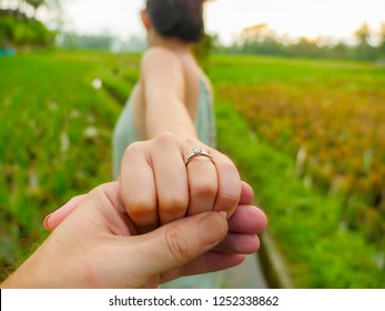 close up couple hands man holding happy fiance hand with diamond engagement ring on her finger after wedding proposal at tropical beautiful and romantic spot proposing marriage