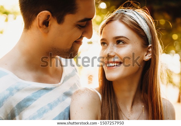 お互いを見つめ合うカップルの接写 夕日を背に屋外で付き合う愛情のある男女 の写真素材 今すぐ編集